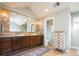 Bathroom featuring double sinks, a large mirror, and access to a separate toilet room at 924 Glen Oaks Ave, Castle Pines, CO 80108