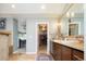 A stylish bathroom with double sinks leading to a walk-in closet and bedroom at 924 Glen Oaks Ave, Castle Pines, CO 80108