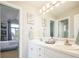 Well-lit bathroom with double vanity, framed mirror, and access to the bedroom at 924 Glen Oaks Ave, Castle Pines, CO 80108