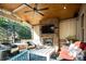 Outdoor covered patio features a stone fireplace, ceiling fan and a seating area at 924 Glen Oaks Ave, Castle Pines, CO 80108