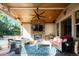 Covered patio featuring a stone fireplace, ceiling fan and comfortable seating at 924 Glen Oaks Ave, Castle Pines, CO 80108