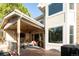 Covered patio with fireplace, ceiling fan, comfortable seating, and an outdoor dining area at 924 Glen Oaks Ave, Castle Pines, CO 80108