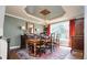 Sophisticated dining room featuring a chandelier, tray ceiling, hardwood floors, and large windows at 924 Glen Oaks Ave, Castle Pines, CO 80108