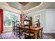 Elegant dining room with chandelier, tray ceiling, hardwood floors, and large windows at 924 Glen Oaks Ave, Castle Pines, CO 80108