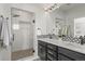 Well-lit bathroom featuring glass enclosed shower, dual vanity with black cabinets and stylish tile flooring at 5240 N Raleigh St, Denver, CO 80212