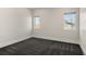 Empty bedroom with gray carpet, light walls, electrical outlets, baseboards, and windows overlooking neighborhood at 5240 N Raleigh St, Denver, CO 80212