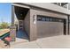 Close-up of a modern townhome with a brick facade, two-car garage, and a covered entryway with a red door at 5240 N Raleigh St, Denver, CO 80212