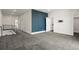 A carpeted hallway featuring an accent wall, modern railing, and doorways leading to other rooms at 5240 N Raleigh St, Denver, CO 80212