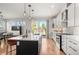 Well-lit kitchen with island, sleek appliances, and an eat-in area with sliding doors offering outdoor views at 5240 N Raleigh St, Denver, CO 80212