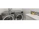 A laundry room featuring front load washer and dryer and a stylish decorative backsplash at 5240 N Raleigh St, Denver, CO 80212