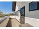 Wide view of the exterior patio featuring wood flooring, sleek railing, and a wall of windows and a door at 5240 N Raleigh St, Denver, CO 80212