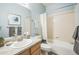 Bathroom with a light wood vanity, white countertop, and white shower and tub combination at 7080 Simms St # 105, Arvada, CO 80004