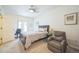Cozy bedroom with a comfortable chair, neutral carpet, and a window with ample natural light at 7080 Simms St # 105, Arvada, CO 80004