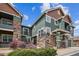 Beautiful townhome with green siding, stone accents, and well-maintained landscaping, creating inviting curb appeal at 7080 Simms St # 105, Arvada, CO 80004