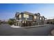 Street view of townhomes with stone and green siding and attached garages at 7080 Simms St # 105, Arvada, CO 80004