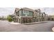 Row of townhomes with green siding, stone accents, and convenient garage parking for each unit at 7080 Simms St # 105, Arvada, CO 80004