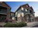 Townhome with a combination of stone and green siding, front porch, and landscaping at 7080 Simms St # 105, Arvada, CO 80004