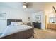 Comfortable main bedroom featuring neutral decor, a ceiling fan, and ensuite bathroom access at 7080 Simms St # 105, Arvada, CO 80004