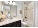Modern bathroom with dark vanity, shower, and toilet at 17637 W 87Th Ave, Arvada, CO 80007