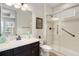 Well-lit bathroom with a single vanity, dark cabinetry, and a walk-in shower with glass doors, offering a clean and modern look at 17637 W 87Th Ave, Arvada, CO 80007