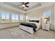 Bright bedroom featuring a tray ceiling, plush carpeting, a ceiling fan, and shuttered windows for natural light and privacy at 17637 W 87Th Ave, Arvada, CO 80007