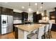 Gourmet kitchen with granite island, stainless appliances, dark cabinetry, and pendant lighting at 17637 W 87Th Ave, Arvada, CO 80007