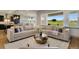 Bright living room with large windows, hardwood floors, and an open concept design at 17637 W 87Th Ave, Arvada, CO 80007