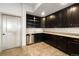 Stylish wet bar area with dark cabinets, granite countertop, and stainless steel dishwasher at 17637 W 87Th Ave, Arvada, CO 80007