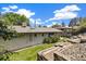 Large backyard with tiered landscaping and a partial view of the exterior elevation of the home at 937 S Cole Dr, Lakewood, CO 80228