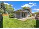 Landscaped backyard featuring a covered patio, well-maintained lawn, and mature trees at 937 S Cole Dr, Lakewood, CO 80228