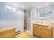 Cozy bathroom featuring a wooden vanity, a shower with a floral curtain, and soft lighting, offering a private retreat at 937 S Cole Dr, Lakewood, CO 80228
