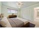 Serene bedroom featuring soft green walls, a large window, a ceiling fan, and a comfortable queen-size bed at 937 S Cole Dr, Lakewood, CO 80228