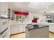 Bright kitchen with a skylight, white cabinetry, stainless steel appliances and a center island at 937 S Cole Dr, Lakewood, CO 80228