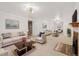 Open living room with neutral carpet, white sofas, fireplace and multiple doors at 937 S Cole Dr, Lakewood, CO 80228