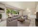 Bright and airy living room features a large picture window with views of trees and natural light, and neutral decor at 937 S Cole Dr, Lakewood, CO 80228