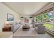 Bright living room with neutral furniture, large windows offering lush backyard views, and contemporary decor at 937 S Cole Dr, Lakewood, CO 80228