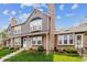 Charming townhouse showcasing brick detailing, steps to the entrance, and a well-maintained lawn at 17108 E Whitaker Dr # B, Aurora, CO 80015