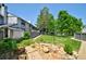 Landscaped backyard with a lush lawn, mature trees, privacy fence, and vibrant flowerbeds creating a serene oasis at 5821 E Ithaca Pl, Denver, CO 80237