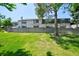 Spacious backyard showcasing lush green grass, mature trees, and a well-maintained fence for privacy and beauty at 5821 E Ithaca Pl, Denver, CO 80237