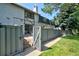 Fenced backyard featuring a lush green lawn, stone patio, and charming home with architectural details at 5821 E Ithaca Pl, Denver, CO 80237