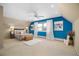 Bright bedroom with blue accent wall, a plush bed, and large windows for ample natural light at 5821 E Ithaca Pl, Denver, CO 80237