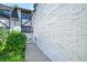 Exterior shot of a white brick townhome, showcasing the side entrance and manicured bushes at 5821 E Ithaca Pl, Denver, CO 80237