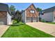 Charming Tudor-style townhome with a brick and white exterior, two-car garage, and well-manicured lawn at 5821 E Ithaca Pl, Denver, CO 80237