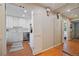 Hallway view featuring wood floors, a mirrored wall and a view into the bright, eat-in kitchen at 5821 E Ithaca Pl, Denver, CO 80237