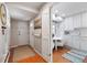 Hallway view featuring wood floors, white trim, and a peek into the bright, eat-in kitchen at 5821 E Ithaca Pl, Denver, CO 80237