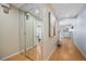 Hallway with decorative mirror, hardwood floors, and neutral paint, leading to other rooms at 5821 E Ithaca Pl, Denver, CO 80237
