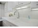 Close-up of a bright kitchen featuring white cabinets, stainless steel hardware, and ample counter space at 5821 E Ithaca Pl, Denver, CO 80237