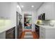 Galley kitchen with white cabinets, stainless steel appliances, and an open view to the dining room at 5821 E Ithaca Pl, Denver, CO 80237