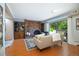 Inviting living room with a brick fireplace, wood floors, and sliding glass doors to an outdoor deck at 5821 E Ithaca Pl, Denver, CO 80237