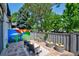 Private patio area featuring stone flooring, stylish outdoor seating, decorative art, and lush green surroundings at 5821 E Ithaca Pl, Denver, CO 80237